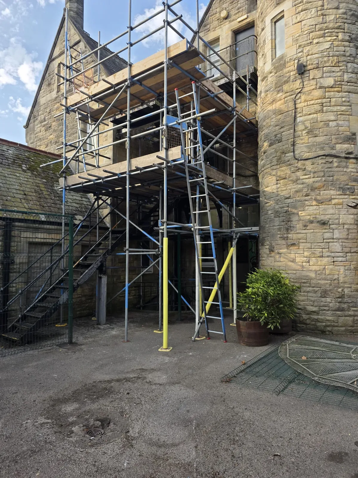 Scaffold tower against a stone church building